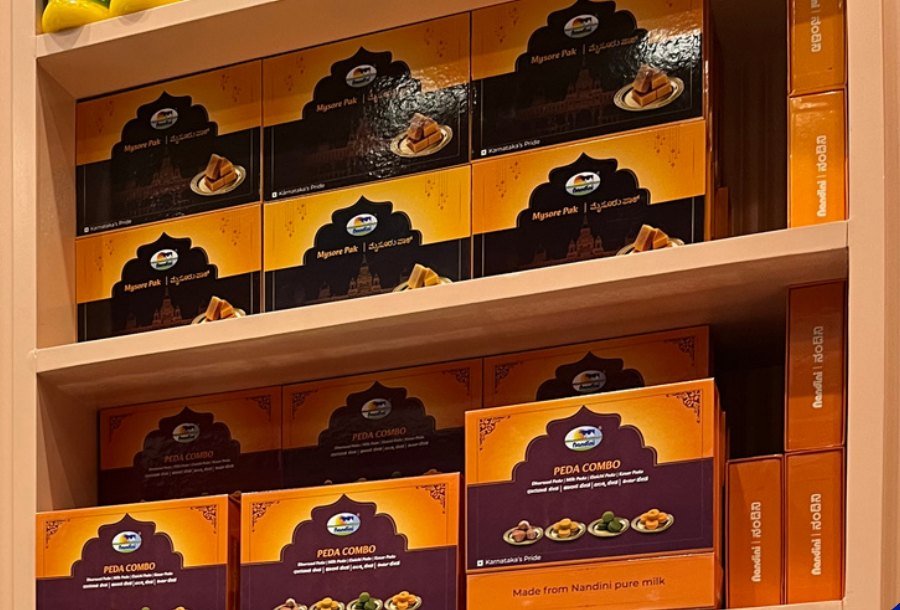 Nandini sweet boxes we designed, stacked on a shelf at Bangalore airport's Terminal 2