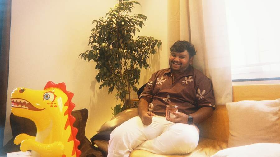 Nikith on a couch with a jar of peanut butter